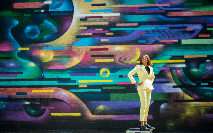 Nabiha Saklayen standing in front of a colorful mural